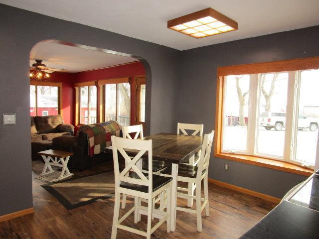 dining space featuring arched walkways, ceiling fan, wood finished floors, and baseboards