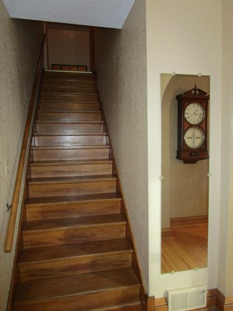 stairway featuring a textured wall and arched walkways