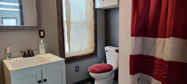 bathroom with toilet, vanity, and a shower with shower curtain