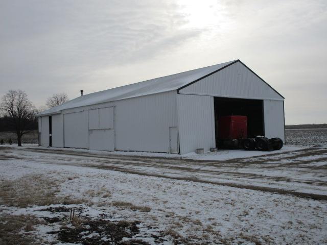 snow covered structure with an outbuilding
