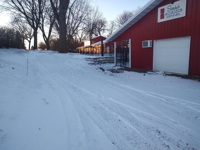 yard covered in snow featuring a garage
