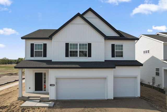 view of front facade with an attached garage, board and batten siding, dirt driveway, and a shingled roof
