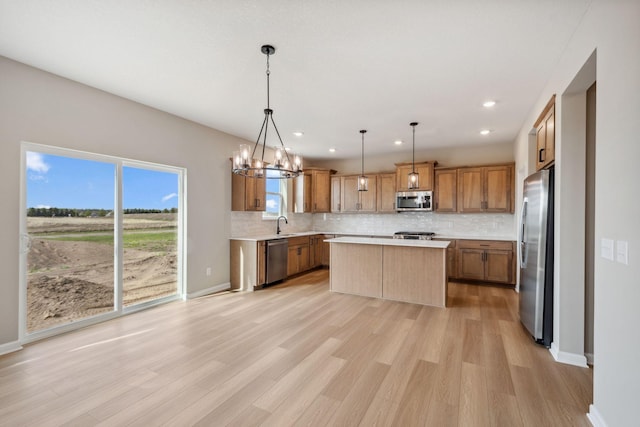 kitchen featuring appliances with stainless steel finishes, backsplash, light countertops, light wood-style flooring, and recessed lighting