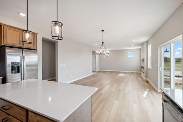 kitchen with appliances with stainless steel finishes, recessed lighting, a chandelier, light countertops, and light wood-type flooring