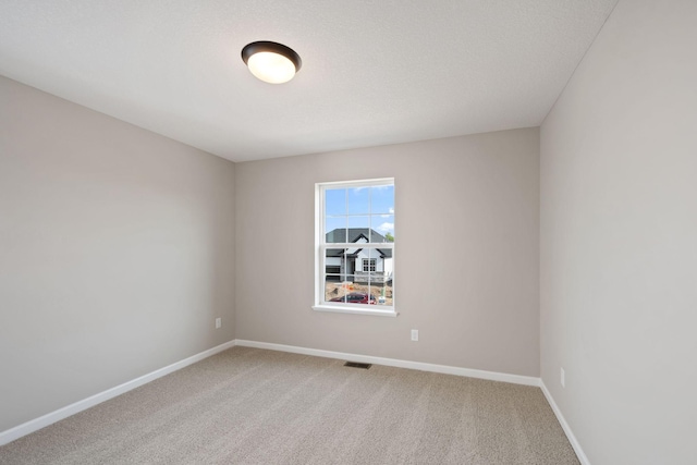 empty room with baseboards and light colored carpet