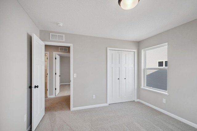 unfurnished bedroom featuring baseboards, carpet, and a closet