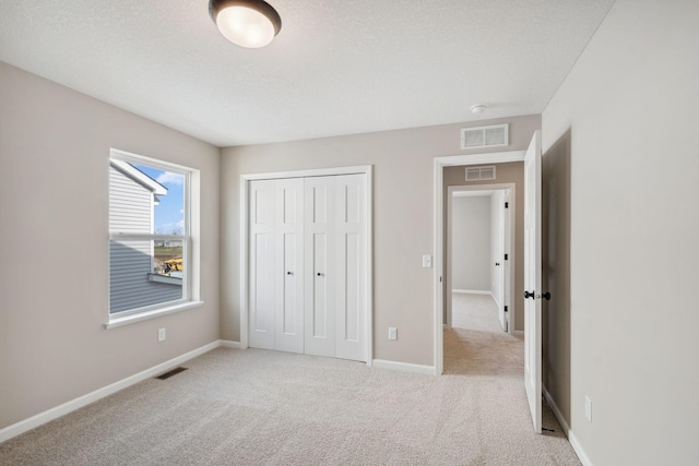 unfurnished bedroom with carpet flooring, a closet, and baseboards