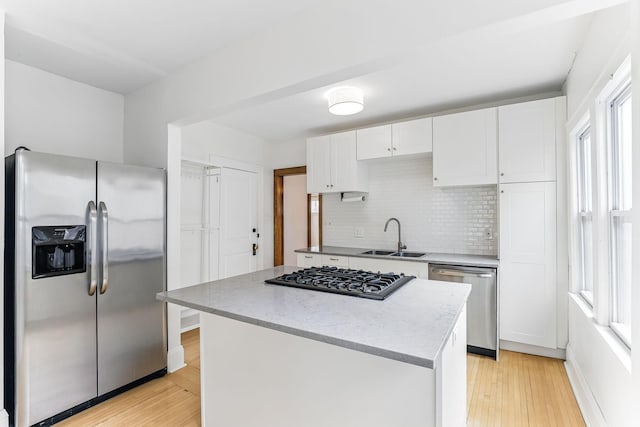 4228 Minnehaha Ave, Minneapolis, MN 55406 - kitchen featuring stainless steel appliances, a sink, tasteful backsplash, white cabinets, and plenty of natural light