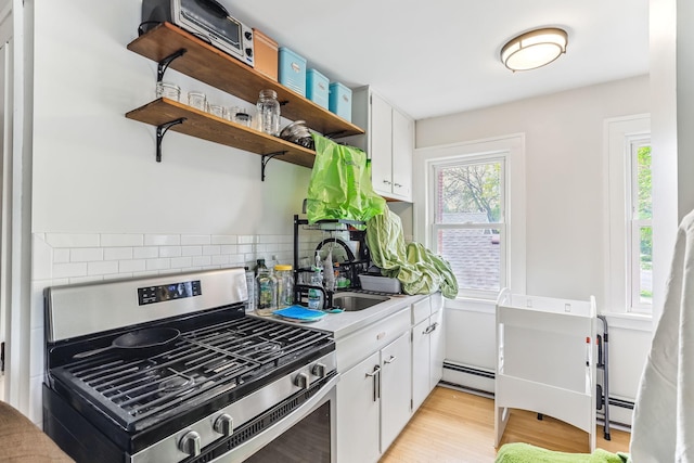 4228 Minnehaha Ave, Minneapolis, MN 55406 - kitchen with stainless steel range with gas stovetop, a sink, a baseboard radiator, decorative backsplash, and open shelves