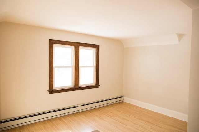 4228 Minnehaha Ave, Minneapolis, MN 55406 - empty room featuring a baseboard heating unit, light wood finished floors, vaulted ceiling, and baseboards