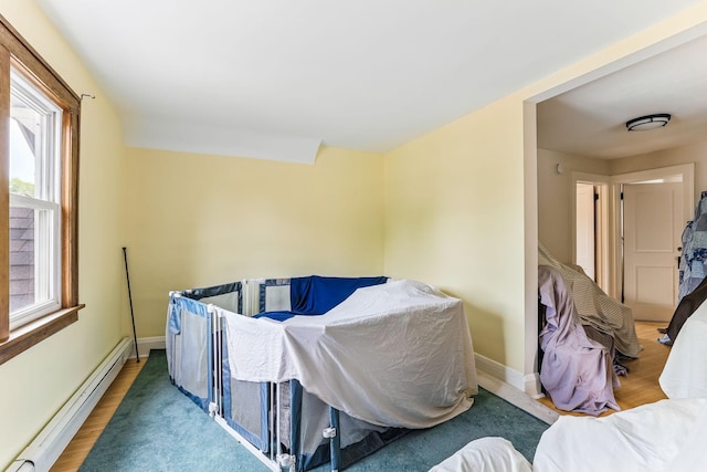 4228 Minnehaha Ave, Minneapolis, MN 55406 - bedroom with baseboard heating, wood finished floors, and baseboards