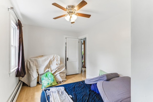 4228 Minnehaha Ave, Minneapolis, MN 55406 - bedroom featuring a baseboard heating unit, wood finished floors, and a ceiling fan