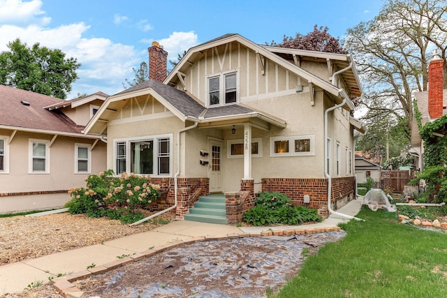 4228 Minnehaha Ave, Minneapolis, MN 55406 - view of front of house with a chimney, stucco siding, a shingled roof, and brick siding