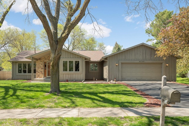 view of front of home featuring a garage and asphalt driveway