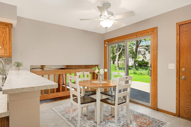 dining room featuring ceiling fan, baseboards, and light tile patterned floors