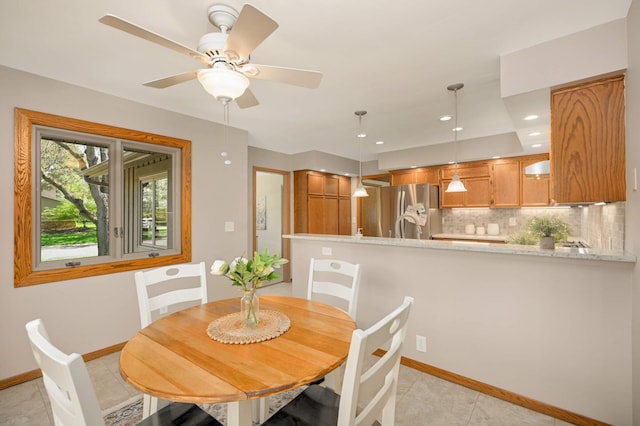 dining area with baseboards, light tile patterned floors, and a ceiling fan