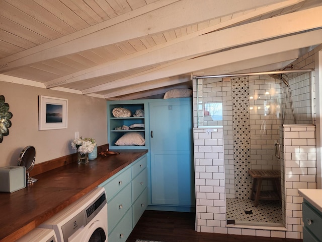 interior space featuring beam ceiling, vanity, washer / dryer, and a shower stall