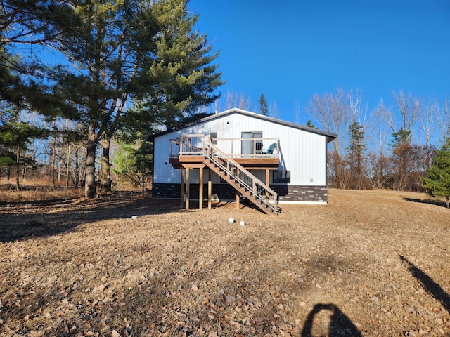 rear view of property featuring a deck and stairway