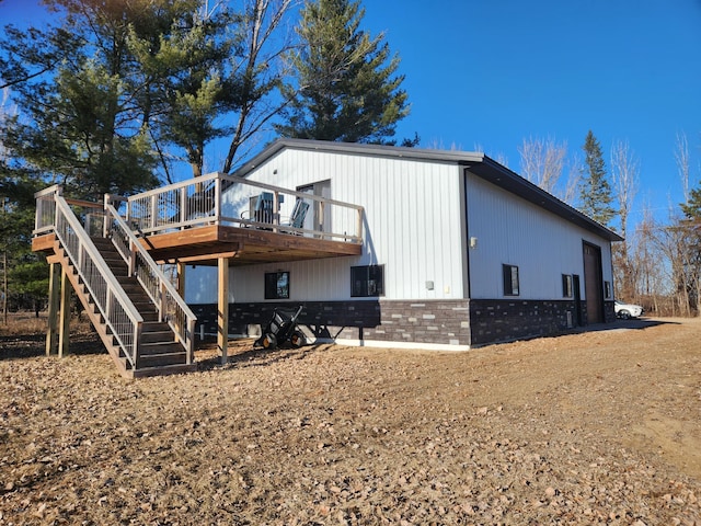 rear view of property featuring a deck, stairs, and brick siding