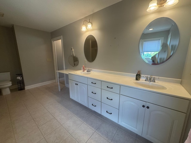 11474 Laketowne Dr, Albertville, MN 55301 - full bathroom with double vanity, tile patterned flooring, toilet, and baseboards