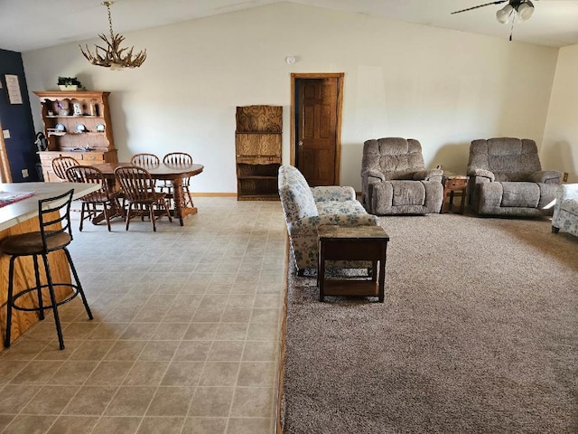 living room with baseboards, a ceiling fan, and lofted ceiling