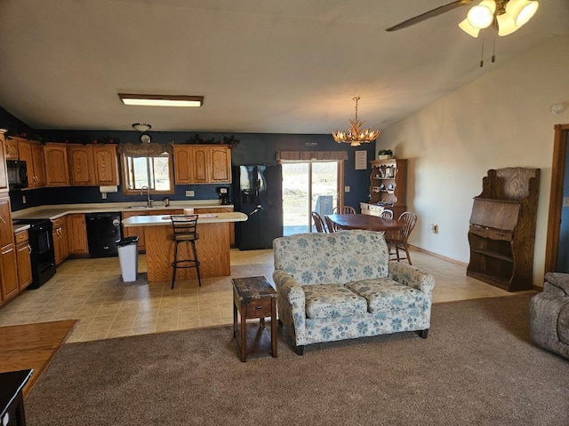 living area with light tile patterned floors, vaulted ceiling, ceiling fan with notable chandelier, and light colored carpet