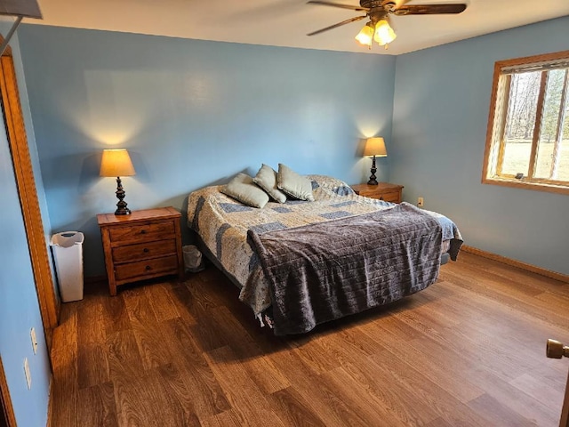 bedroom with baseboards, a ceiling fan, and wood finished floors