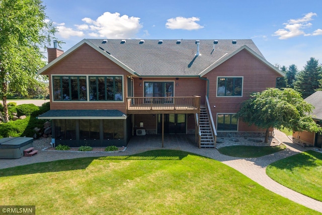 rear view of house featuring stairs, a deck, a hot tub, a patio, and a yard