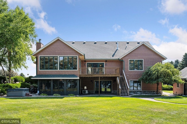 back of house featuring stairs, a lawn, a hot tub, and a wooden deck