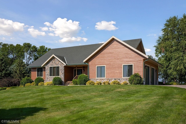 view of front of house featuring a front lawn, stone siding, and a garage