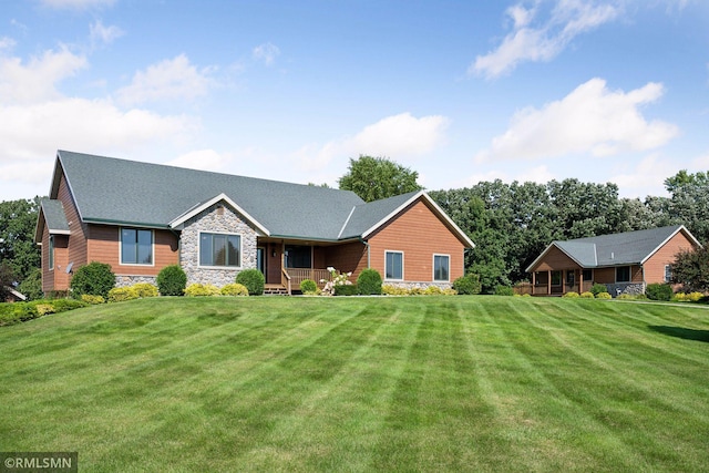 ranch-style home with a front lawn, a porch, and stone siding