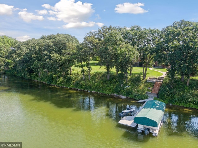 view of dock featuring a water view and a yard
