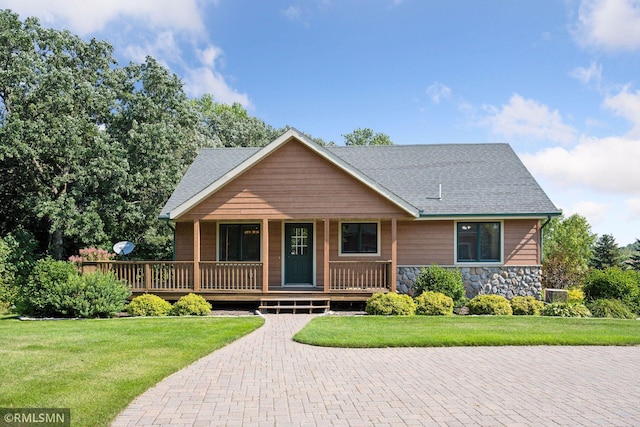 view of front of property featuring stone siding, a shingled roof, a front lawn, and a porch