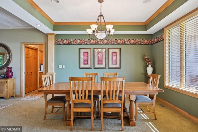 dining area with a tray ceiling, baseboards, crown molding, and a chandelier
