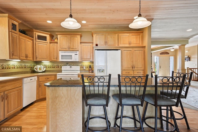 kitchen featuring white appliances, wooden ceiling, a kitchen breakfast bar, and a kitchen island