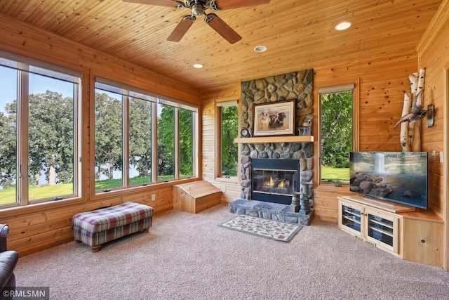 carpeted living area featuring a wealth of natural light, wooden ceiling, and wood walls