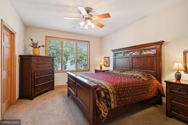 bedroom with light colored carpet, ceiling fan, and a textured ceiling