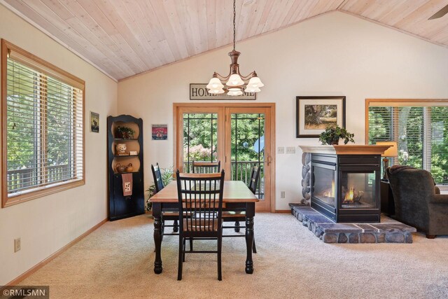 dining room with lofted ceiling, a notable chandelier, and carpet floors