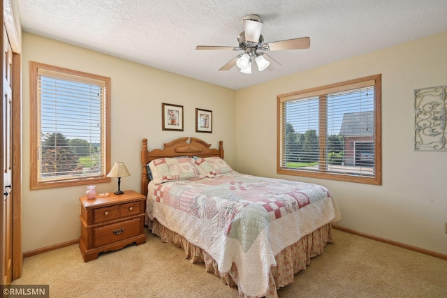 bedroom featuring baseboards, multiple windows, and light carpet