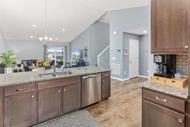10120 189th Ave NW, Elk River, MN 55330 - kitchen featuring stainless steel dishwasher, a sink, open floor plan, vaulted ceiling, and light stone countertops