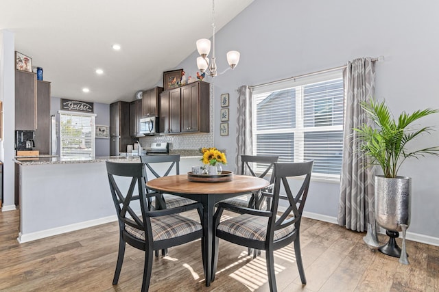10120 189th Ave NW, Elk River, MN 55330 - dining area featuring light wood-style floors, a chandelier, vaulted ceiling, recessed lighting, and baseboards