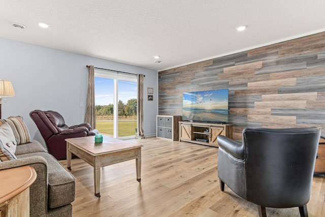 10120 189th Ave NW, Elk River, MN 55330 - living room with an accent wall, recessed lighting, a textured ceiling, light wood-style floors, and wood walls