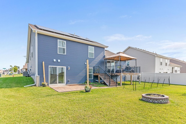 10120 189th Ave NW, Elk River, MN 55330 - rear view of house featuring solar panels, a fire pit, a deck, stairway, and central AC unit
