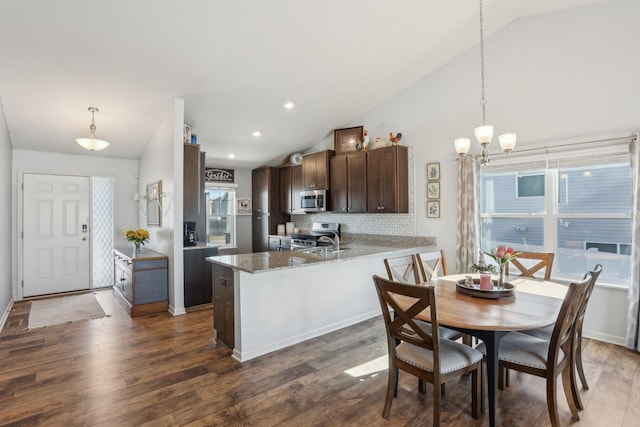 10120 189th Ave NW, Elk River, MN 55330 - kitchen with appliances with stainless steel finishes, vaulted ceiling, dark brown cabinets, dark wood finished floors, and a peninsula