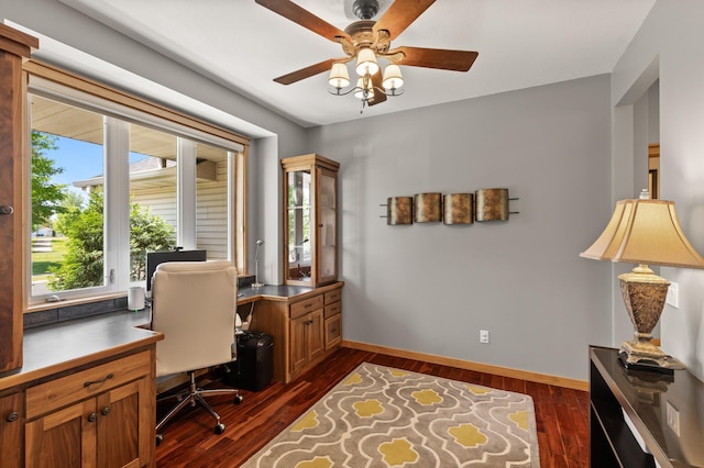 office area with dark wood-type flooring, baseboards, and a ceiling fan