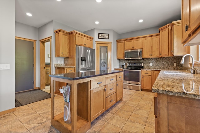 kitchen with appliances with stainless steel finishes, a sink, dark stone countertops, tasteful backsplash, and recessed lighting