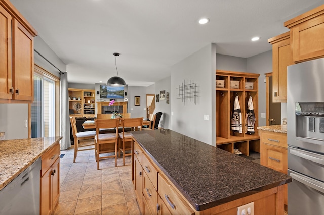kitchen featuring stainless steel appliances, a fireplace, open floor plan, recessed lighting, and a center island