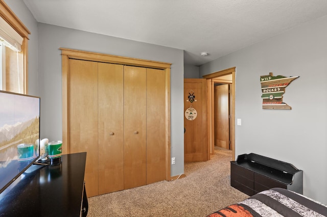 bedroom with light carpet, a closet, and baseboards