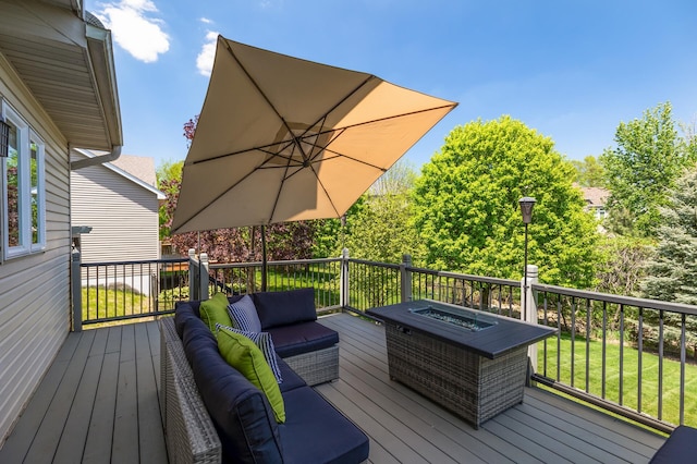 wooden deck featuring an outdoor living space with a fire pit