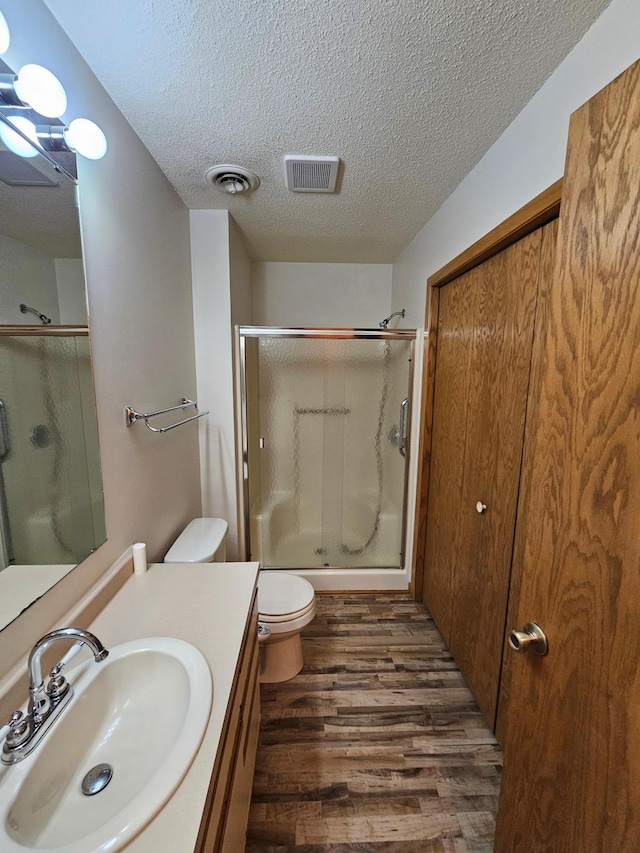 21965 Shady Walk Unit 201, Deerwood, MN 56444 - full bath featuring a textured ceiling, visible vents, wood finished floors, vanity, and a stall shower